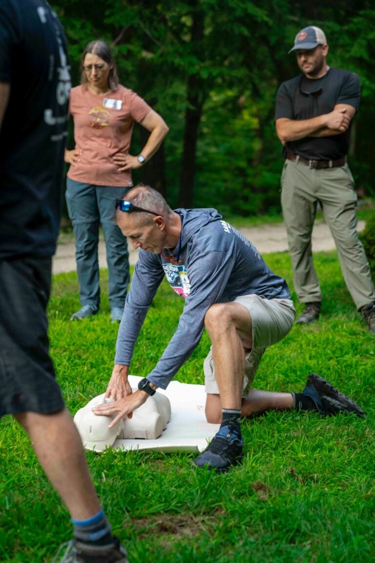 CPR demonstration on a manikin while a group of trainees watches